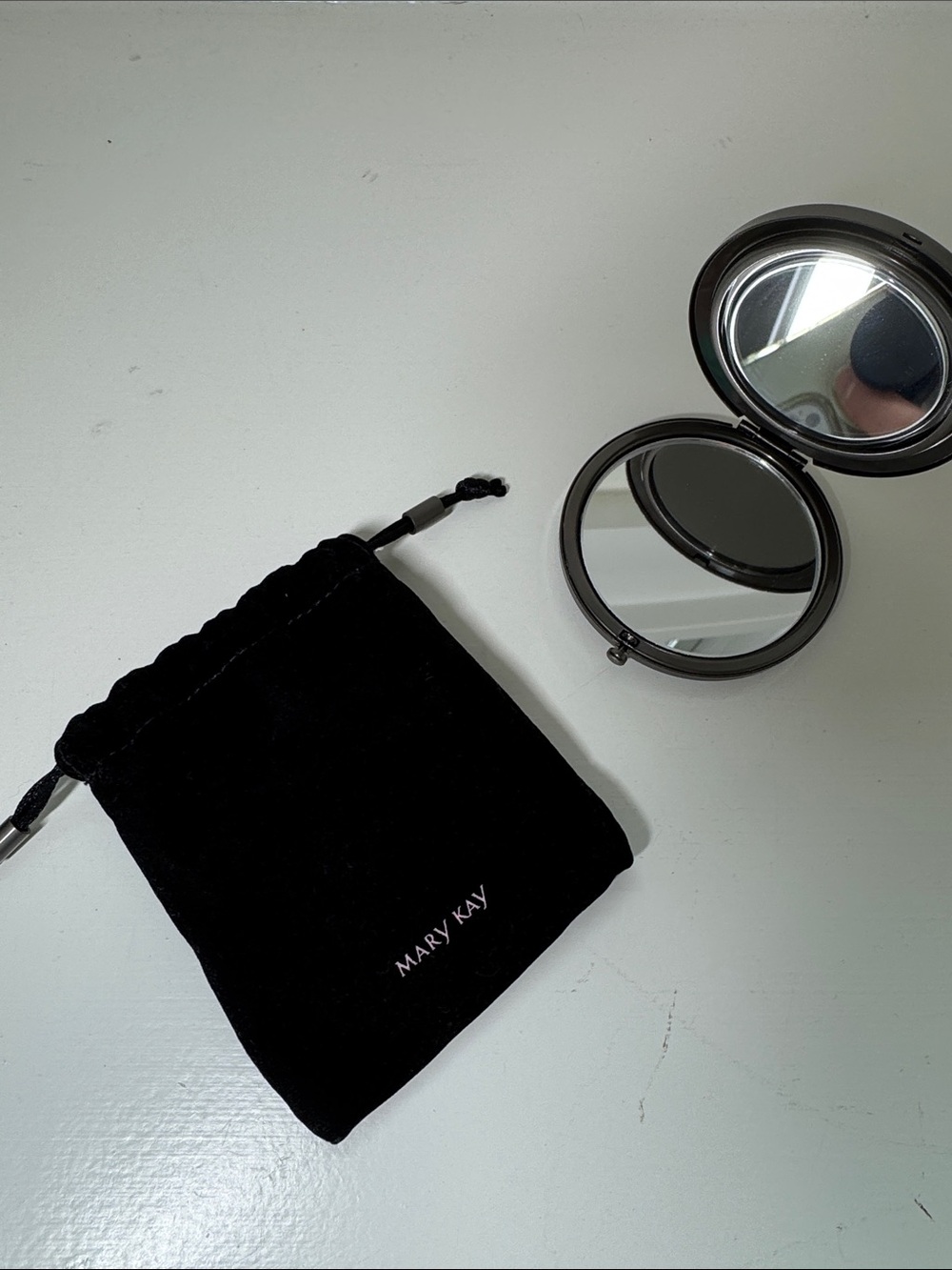 Mary Kay compact mirror in black velveteen drawstring bag.